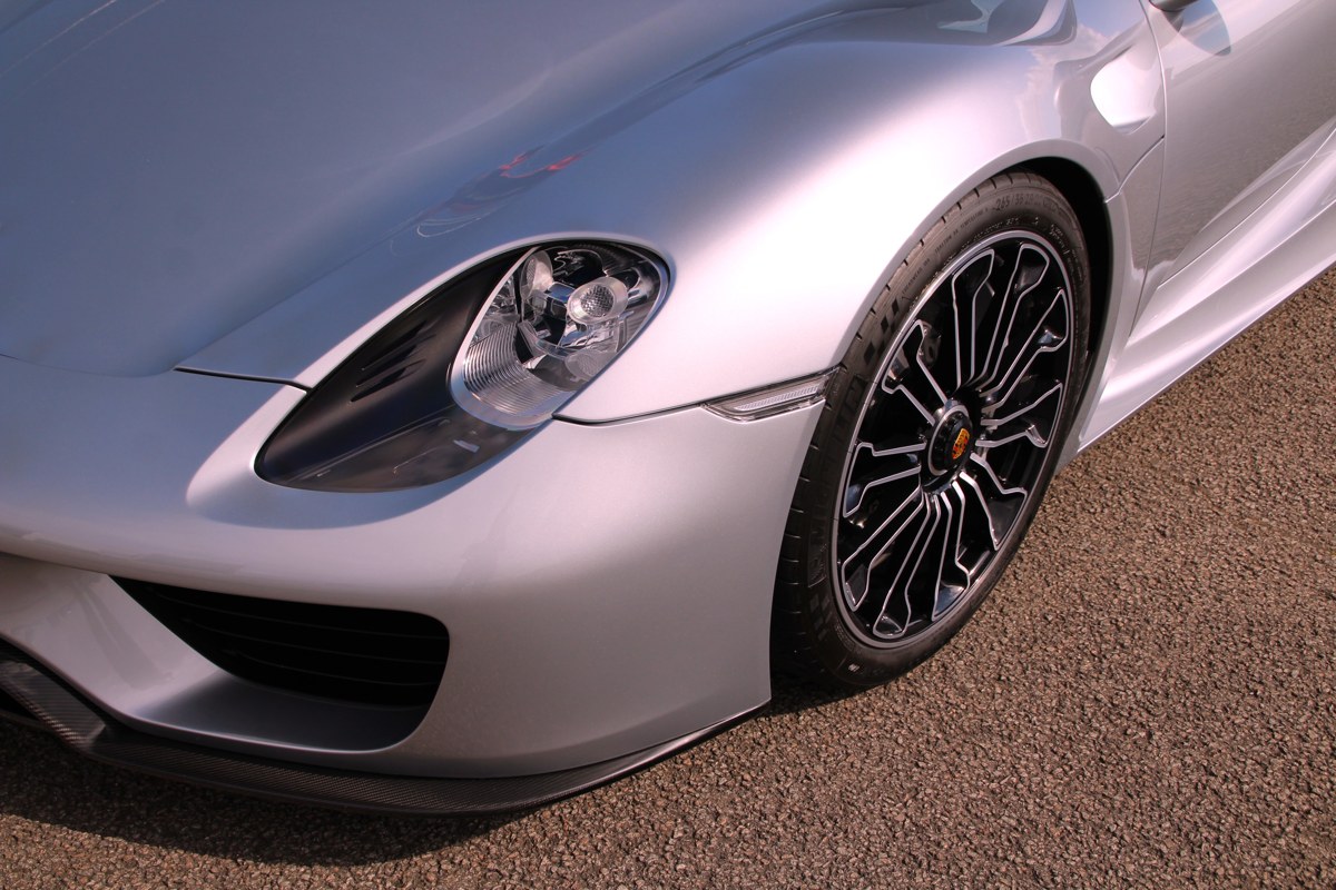 Scheinwerfer und Vorderrad eines silbernen Porsche 918 Spyder